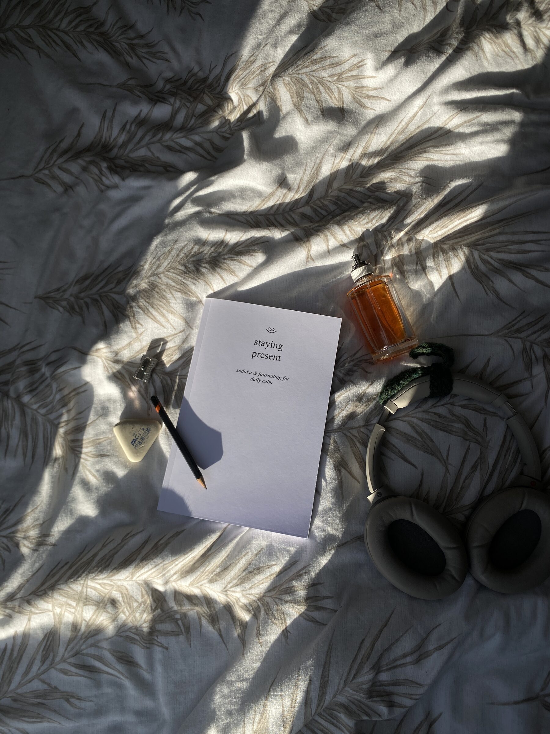 Quiet Mind notebook with pencil, sharpener and headphones in soft morning light