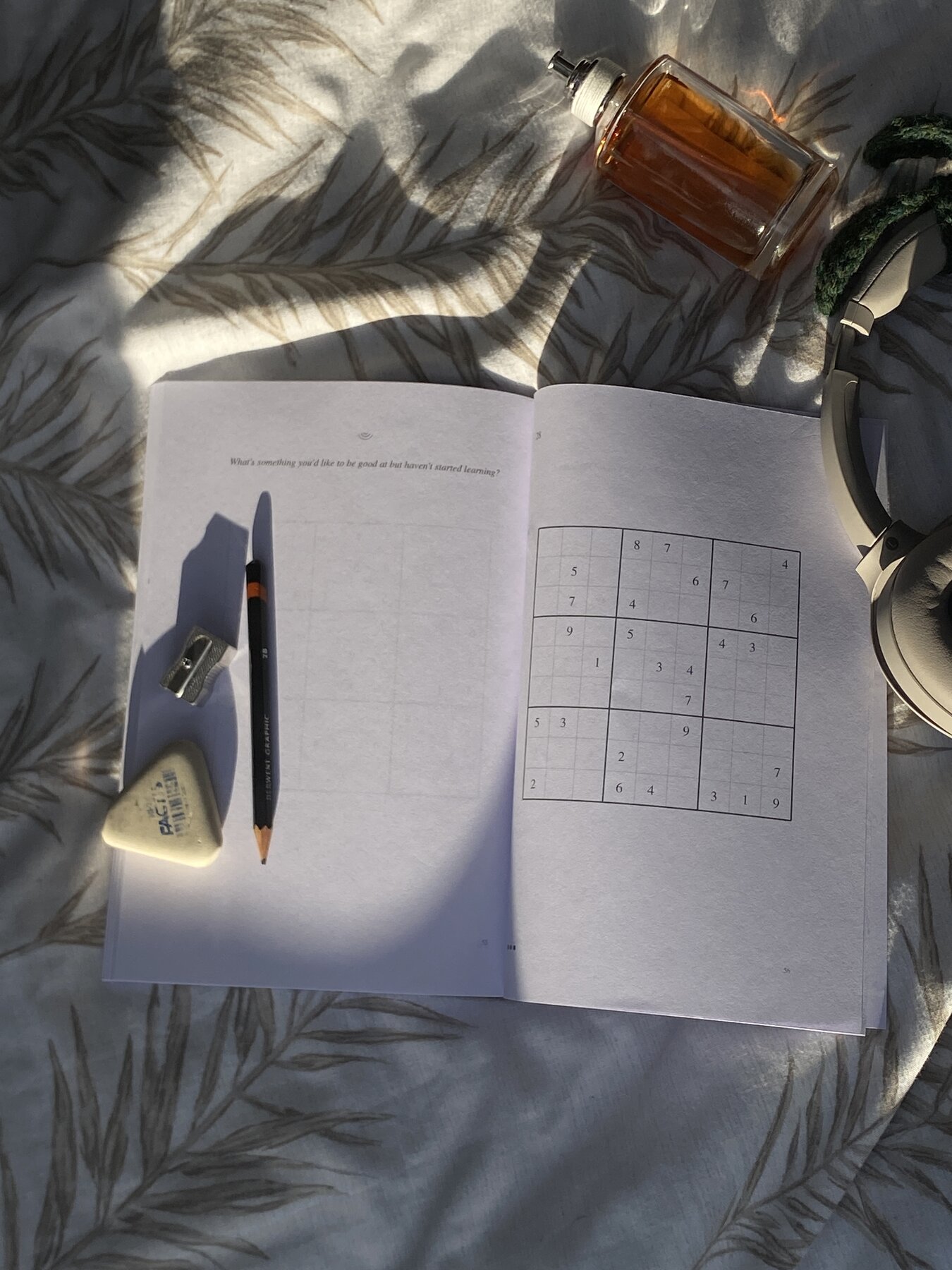 Open spread of Quiet Mind notebook showing a sudoku puzzle and a journal prompt
